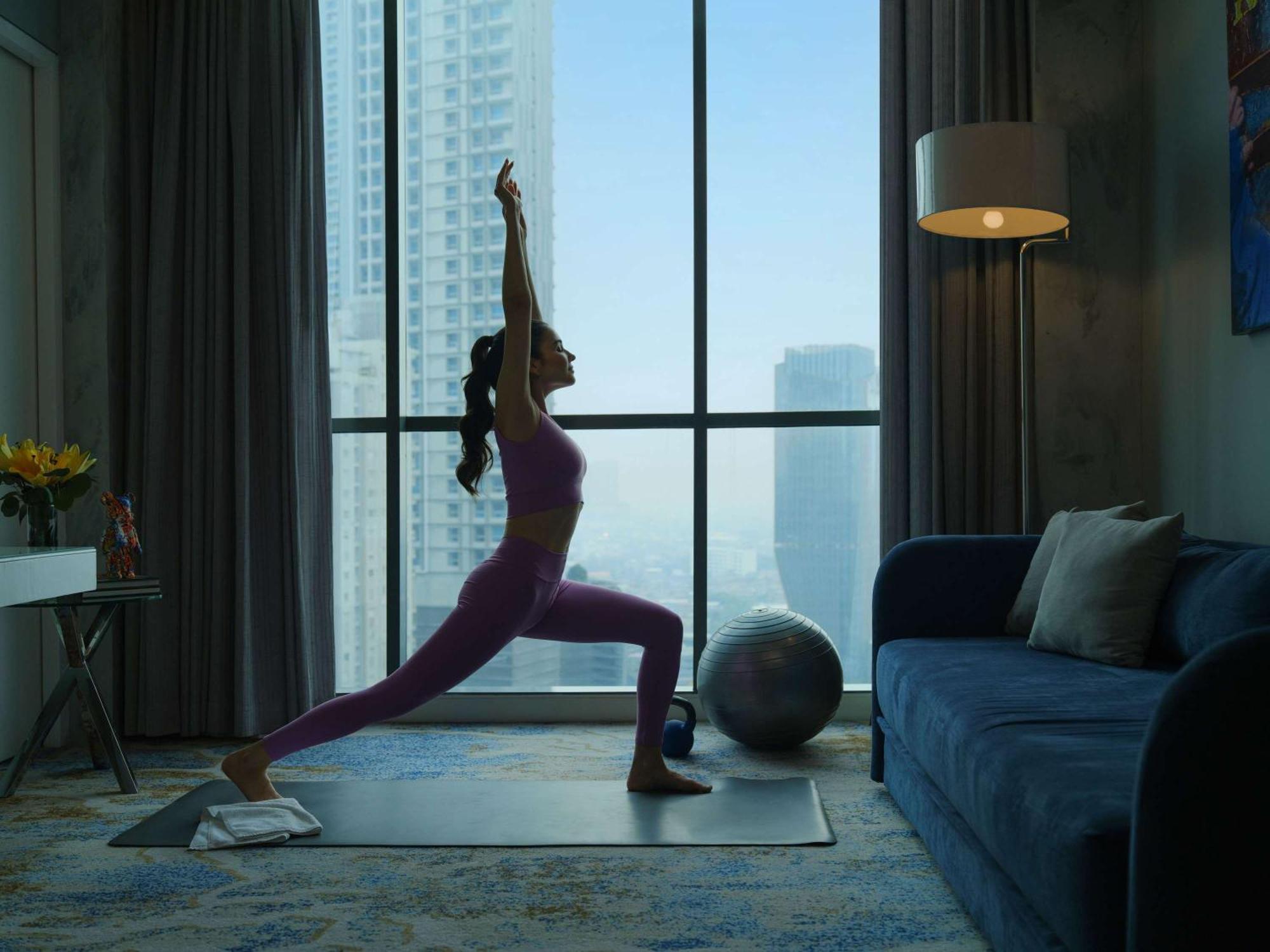 Pullman Jakarta Central Park מראה חיצוני תמונה A woman practicing yoga at home